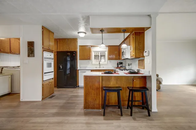 a kitchen with stainless steel appliances granite countertop a refrigerator and a stove top oven