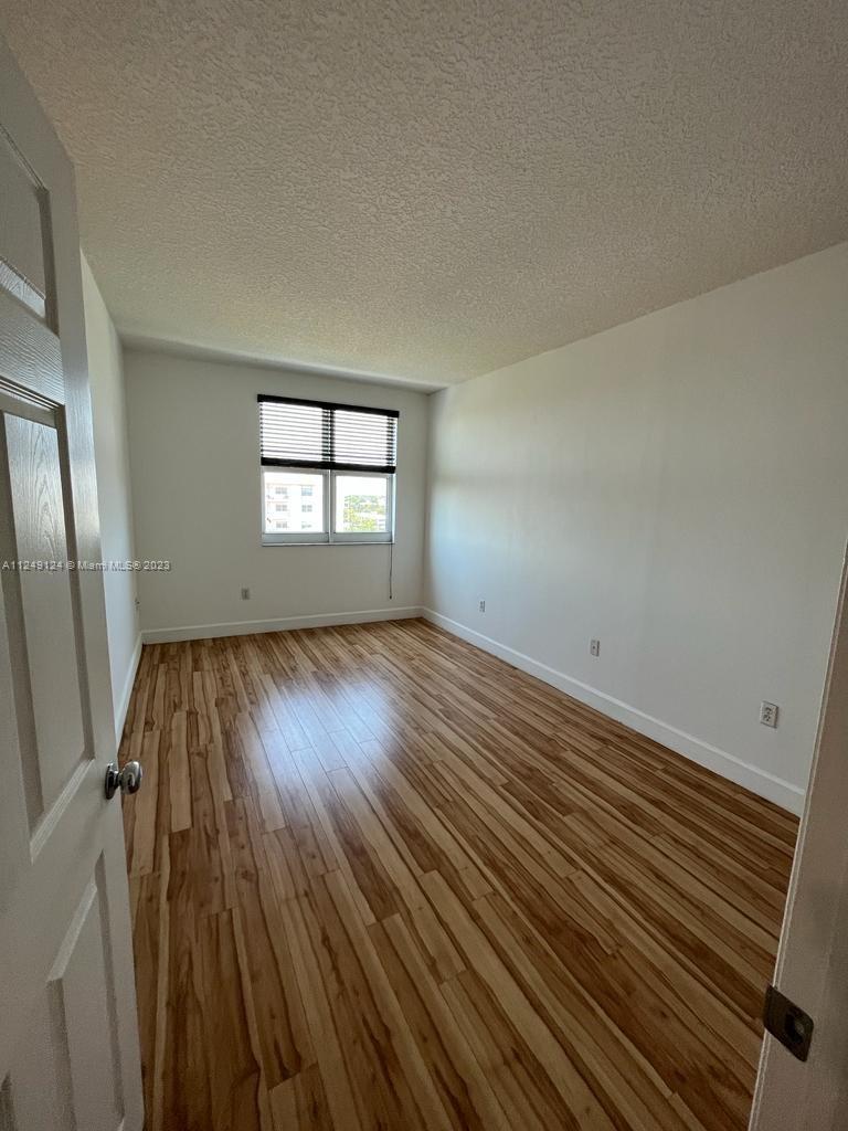 Central Gables Coral Gables, FL 33134 - Photo 12 of 14 an empty room with wooden floor and windows