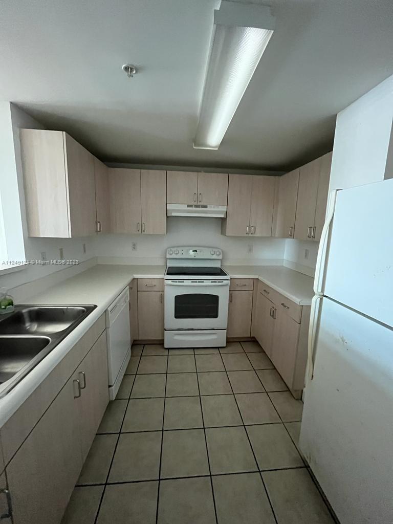 Central Gables Coral Gables, FL 33134 - Photo 5 of 14 a kitchen with a stove sink and cabinets