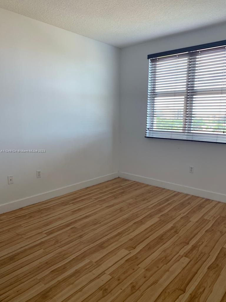 Central Gables Coral Gables, FL 33134 - Photo 9 of 14 wooden floor in an empty room with a window