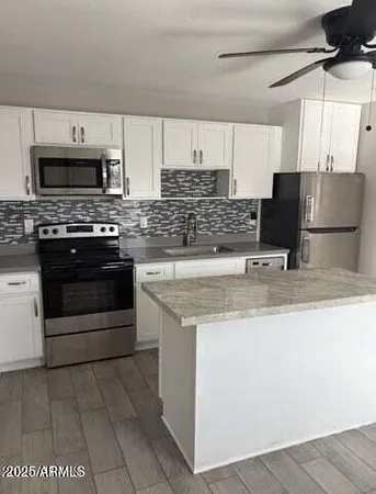 a kitchen with stainless steel appliances granite countertop a stove a sink and a microwave