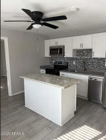a kitchen with stainless steel appliances granite countertop a stove a sink and a microwave