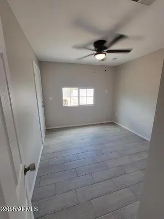 an empty room with windows and fan