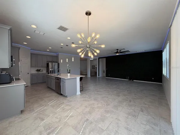 a living room with kitchen island furniture and a flat screen tv