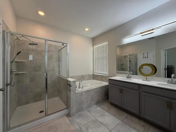 a bathroom with a bathtub shower sink mirror and toilet