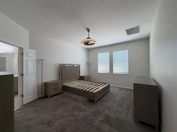 a spacious bedroom with a bed and a window