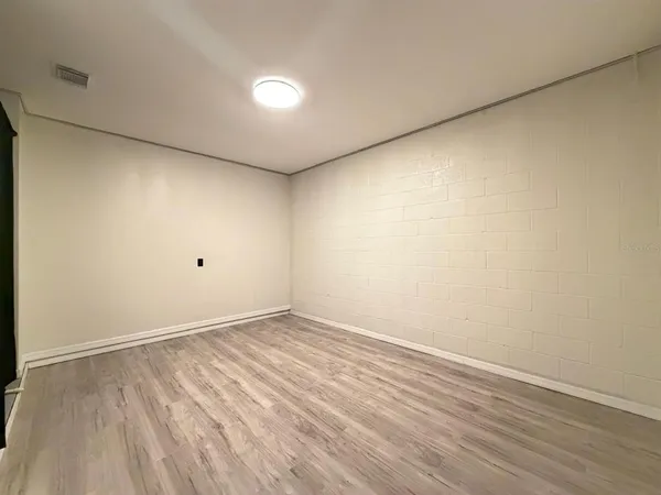 a view of an empty room with wooden floor