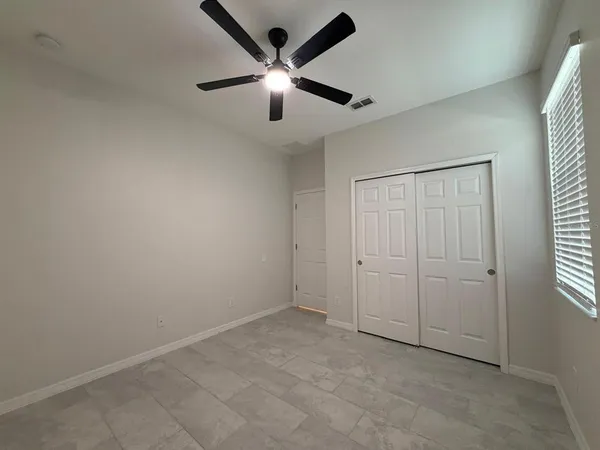 an empty room with chandelier fan
