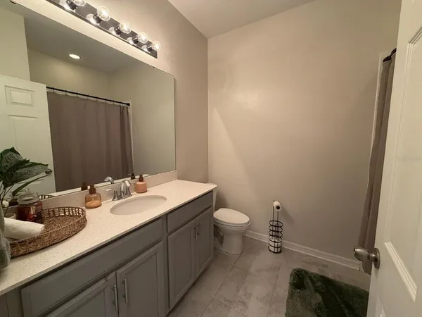 a bathroom with a sink a toilet and mirror