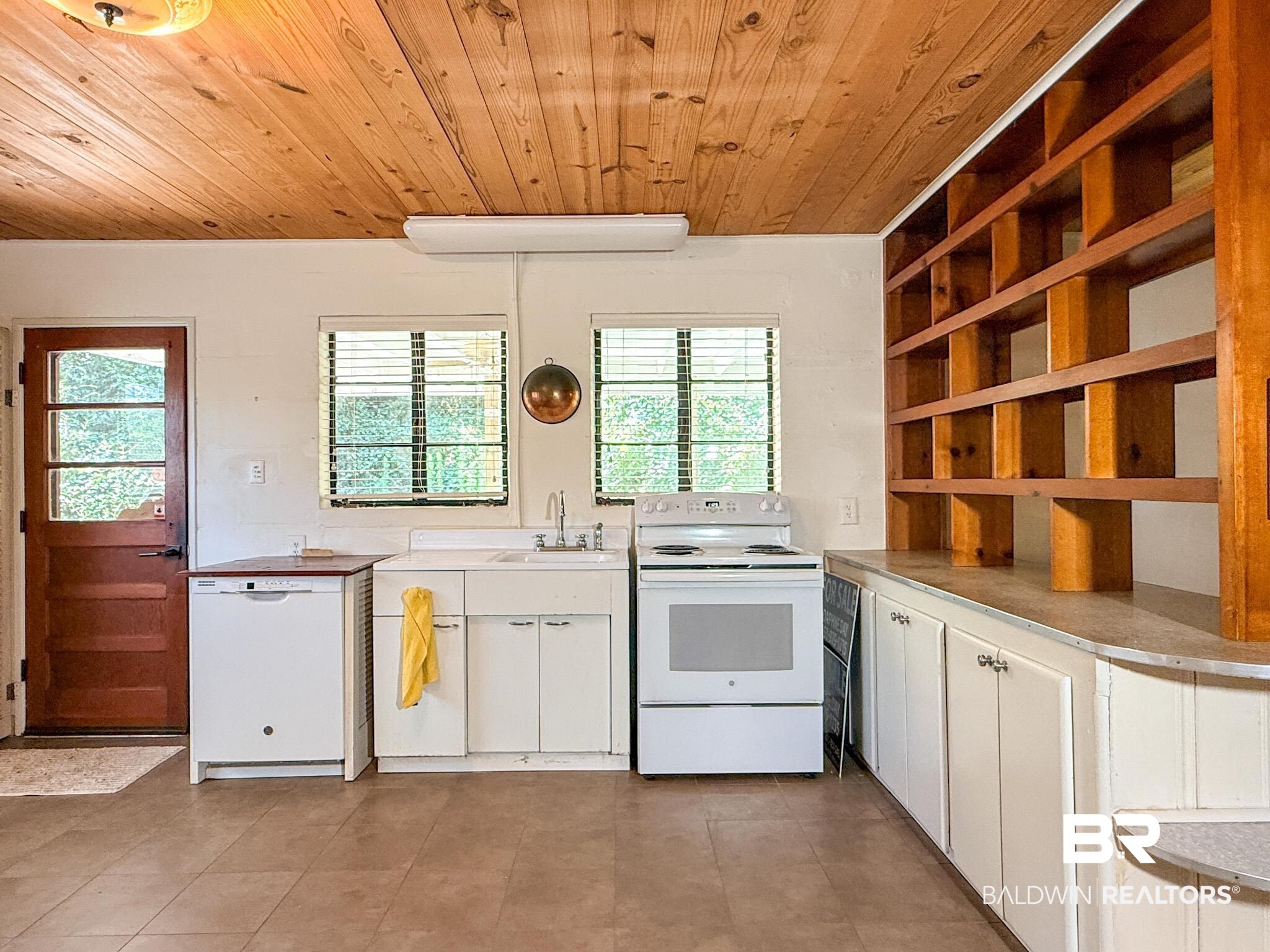18711 Keller Road Foley, AL 36535 - Photo 9 of 38 Kitchen space featuring a wood-finish ceiling, built-in shelving, white cabinetry, and tile flooring