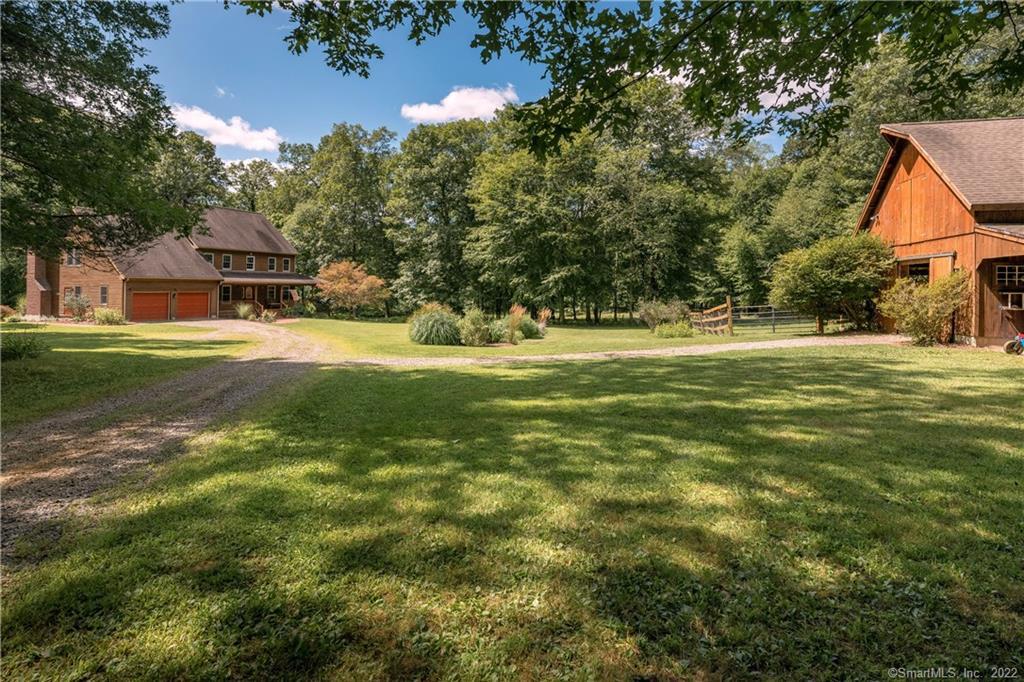 a front view of house with yard and trees all around