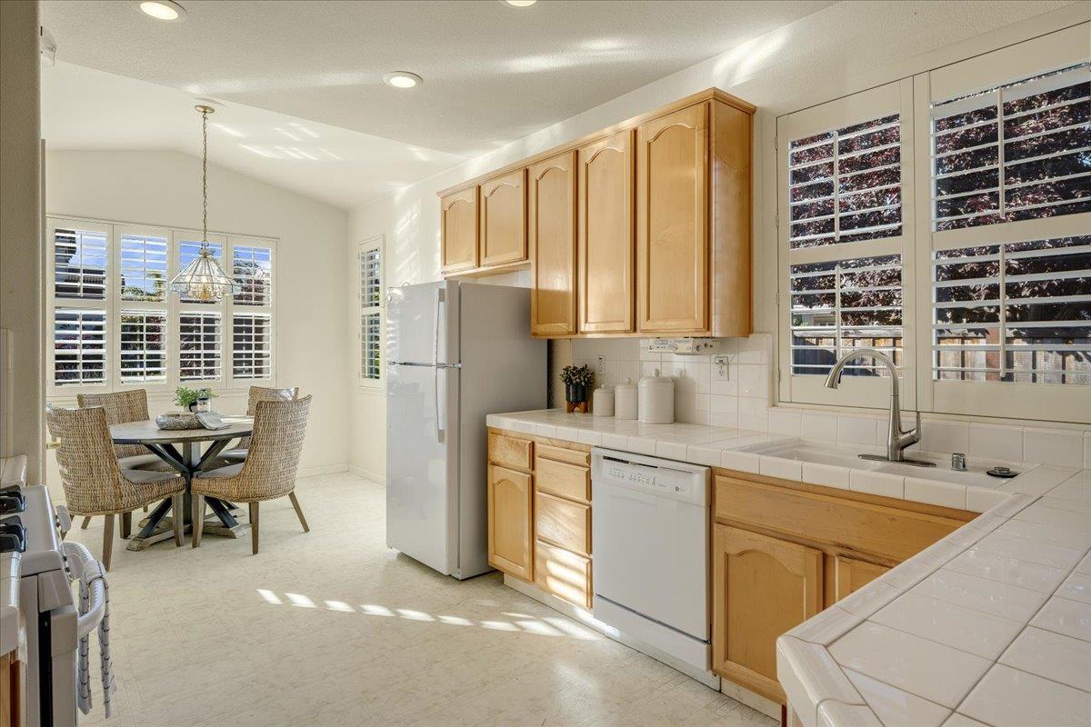 201 Augusta Lane Aptos, CA 95003 - Photo 5 of 36 a kitchen with a table chairs sink refrigerator and cabinets