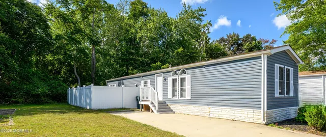 a white house that has a tree in front of it