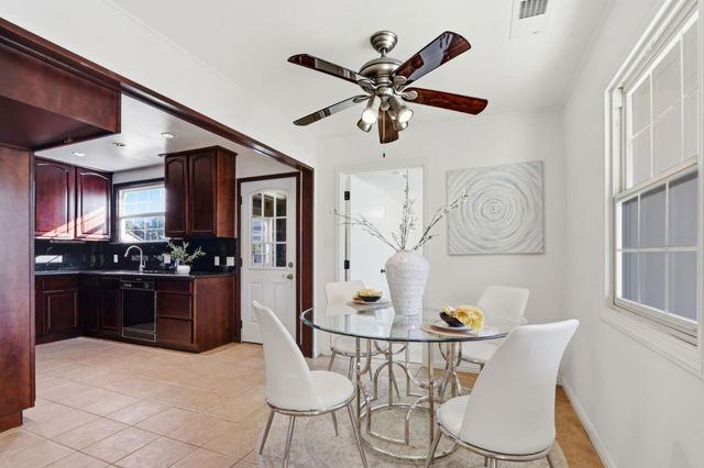 a kitchen with stainless steel appliances kitchen island granite countertop a table chairs and a refrigerator