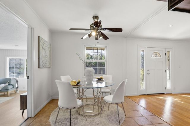 a dining room with furniture a chandelier and wooden floor