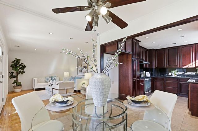 a dining room with furniture a kitchen and chandelier