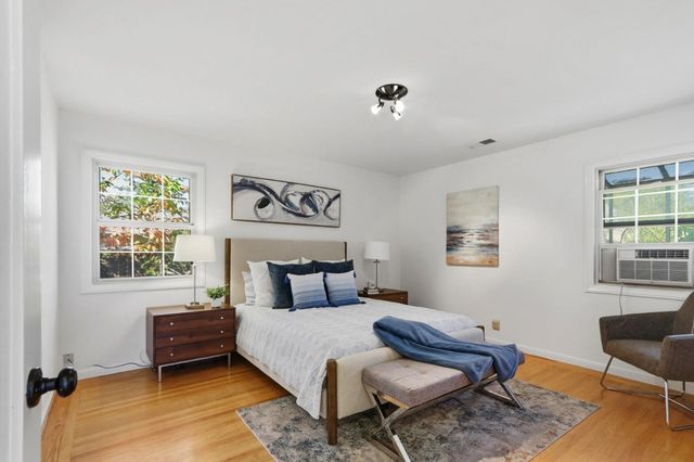 a bedroom with a bed dresser and a window