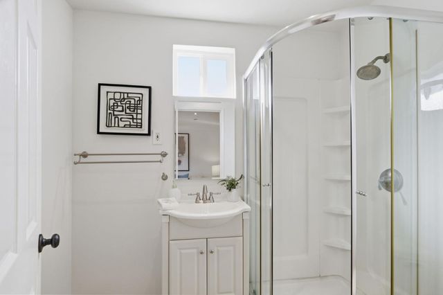 a bathroom with a shower sink and mirror