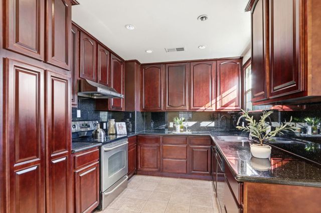 a kitchen with stainless steel appliances granite countertop a refrigerator and a sink