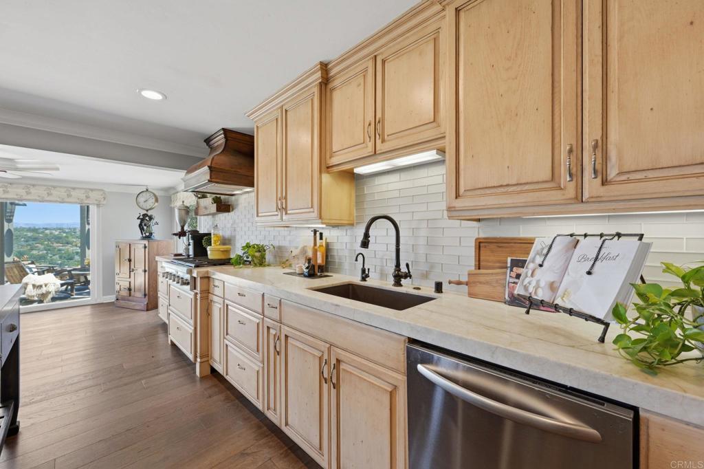 560 Rancho Camino Fallbrook, CA 92028 - Photo 18 of 70 a kitchen with stainless steel appliances granite countertop a sink and cabinets with wooden floor