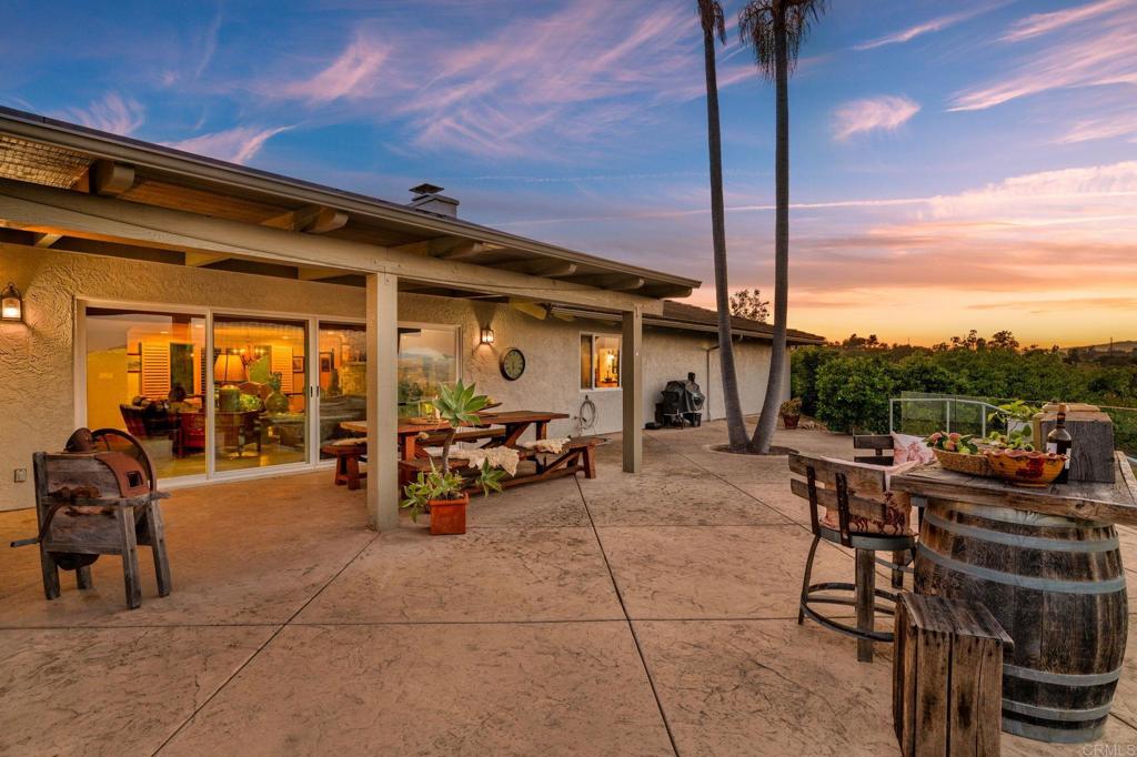 560 Rancho Camino Fallbrook, CA 92028 - Photo 39 of 70 a view of a patio with dining table and chairs with a barbeque grill and a small yard