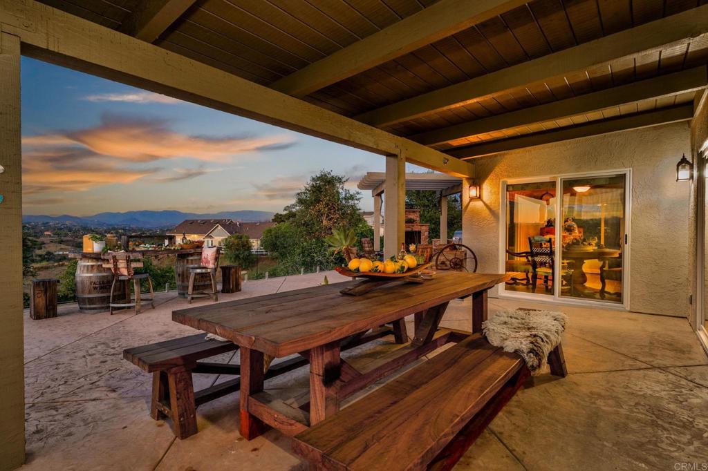560 Rancho Camino Fallbrook, CA 92028 - Photo 42 of 70 a view of a patio with table and chairs a barbeque with wooden floor and fence