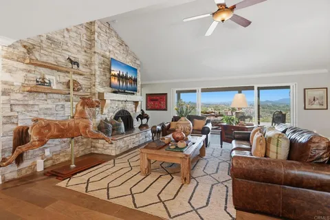 a living room with furniture a fireplace and a large window
