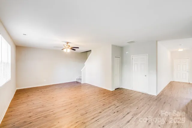 a view of a big room with wooden floor and a ceiling fan