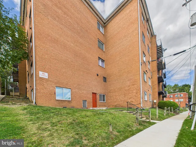 a view of a brick building next to a yard