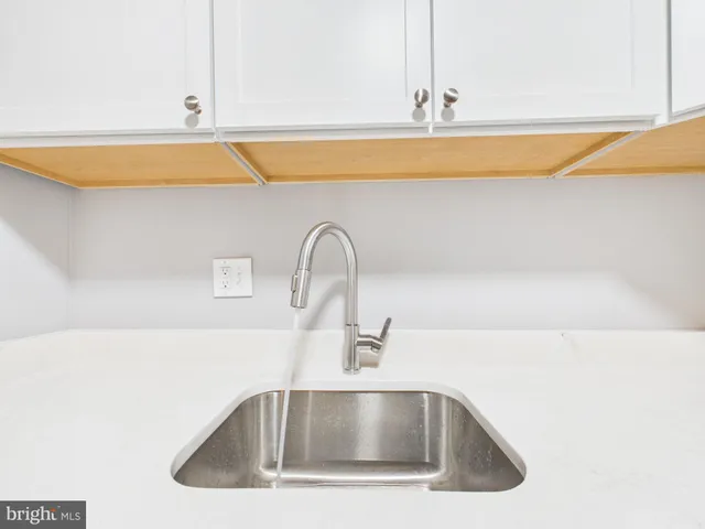 a kitchen with stainless steel appliances white cabinets and a stove top oven