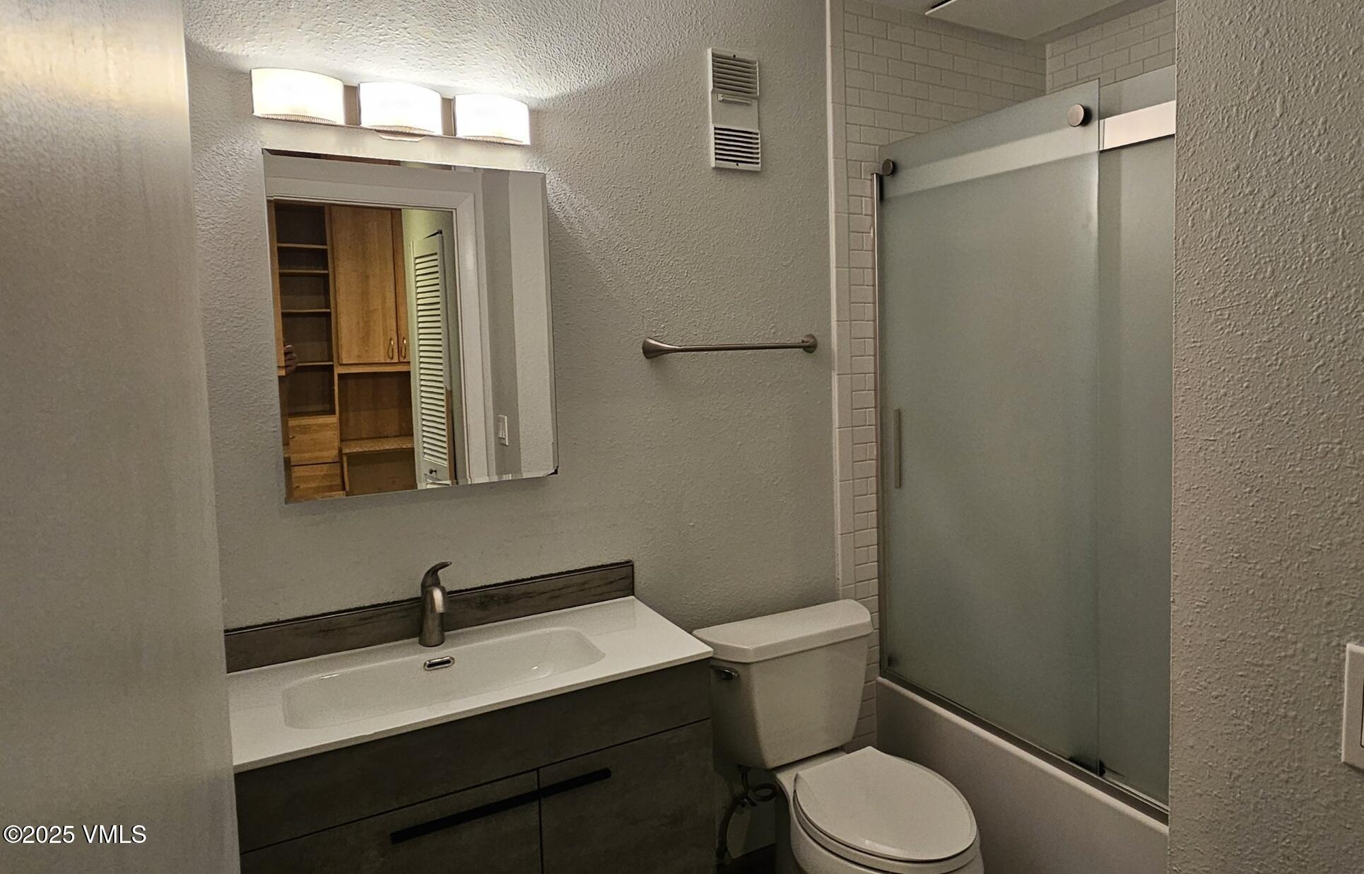 165 Gopher Road, Unit 25 Avon, CO 81620 - Photo 13 of 17 a bathroom with a toilet sink vanity and mirror