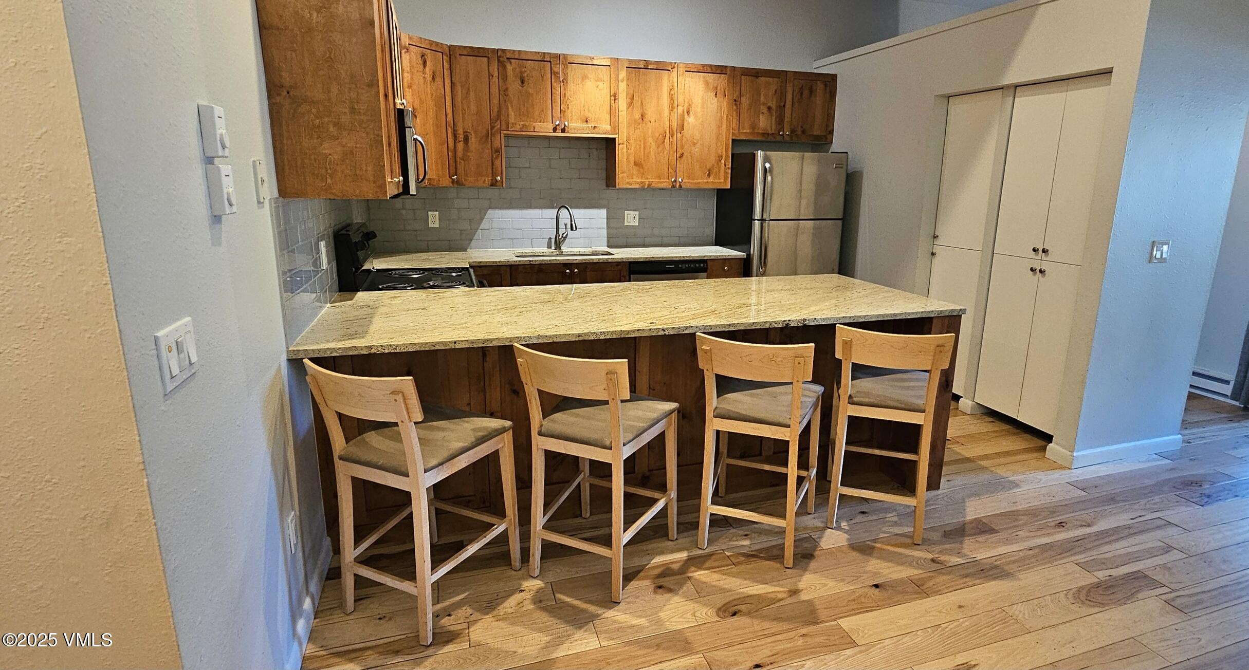 165 Gopher Road, Unit 25 Avon, CO 81620 - Photo 5 of 17 a kitchen with stainless steel appliances kitchen island granite countertop a refrigerator and microwave
