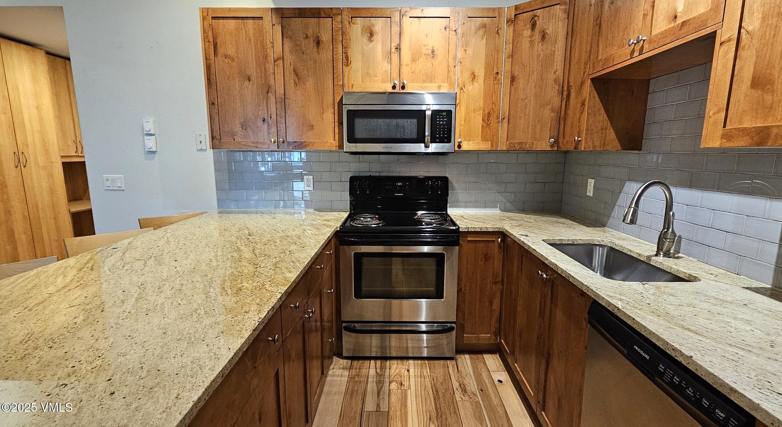 165 Gopher Road, Unit 25 Avon, CO 81620 - Photo 7 of 17 a kitchen with granite countertop a stove a sink and a microwave