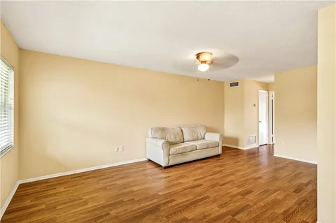 a view of a livingroom with wooden floor and a ceiling fan