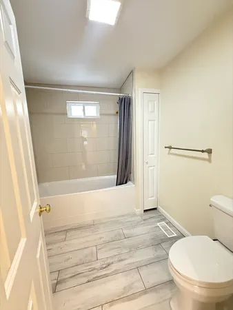 a bathroom with a toilet and a shower