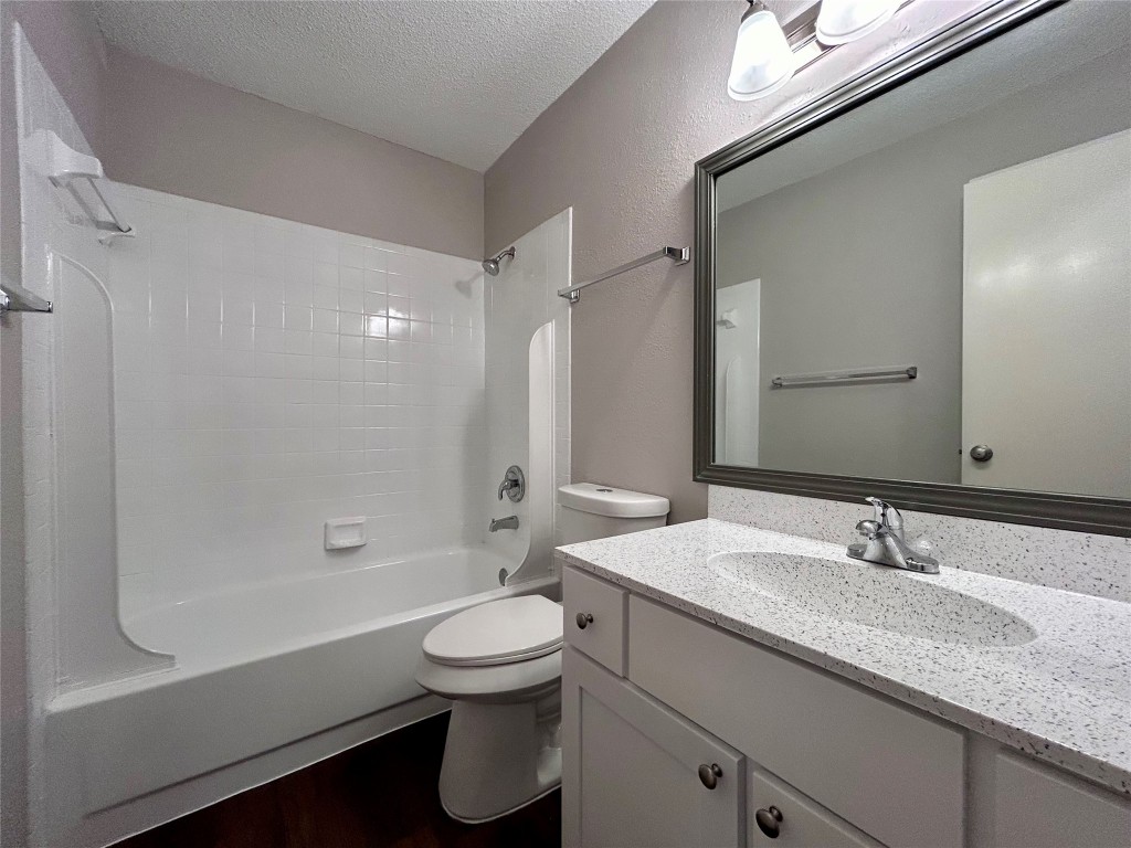 8905 Schick Road, Unit C Austin, TX 78729 - Photo 12 of 25 a bathroom with a granite countertop sink a toilet and shower