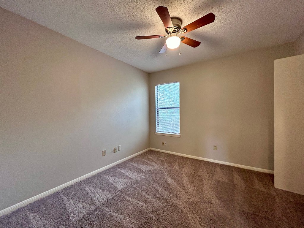 8905 Schick Road, Unit C Austin, TX 78729 - Photo 13 of 25 an empty room with a window and a fan