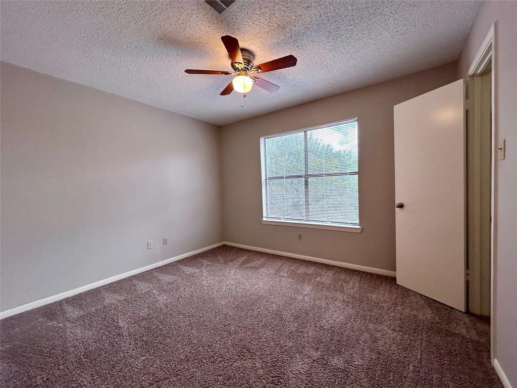 8905 Schick Road, Unit C Austin, TX 78729 - Photo 18 of 25 an empty room with ceiling fan and windows
