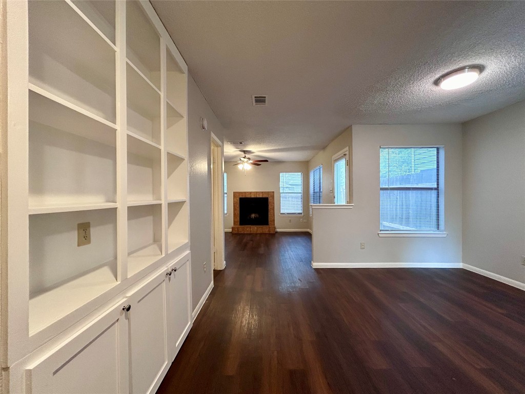 8905 Schick Road, Unit C Austin, TX 78729 - Photo 2 of 25 a view of a hallway with wooden floor and a cabinet