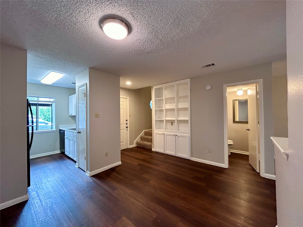 8905 Schick Road, Unit C Austin, TX 78729 - Photo 3 of 25 an empty room with wooden floor and windows