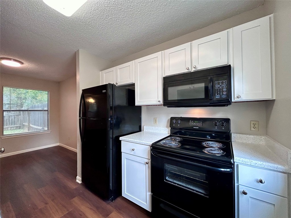 8905 Schick Road, Unit C Austin, TX 78729 - Photo 6 of 25 a kitchen with a refrigerator stove and microwave