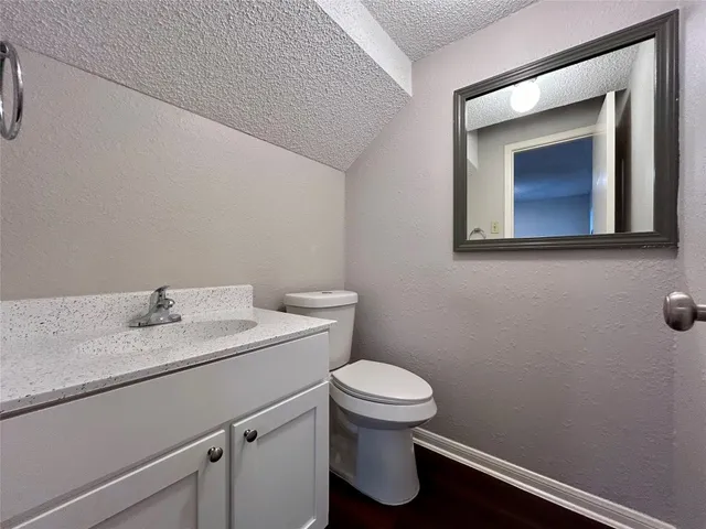 a bathroom with a toilet sink vanity and mirror
