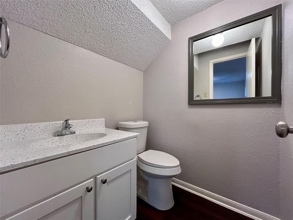 8905 Schick Road, Unit C Austin, TX 78729 - Photo 7 of 25 a bathroom with a toilet sink vanity and mirror