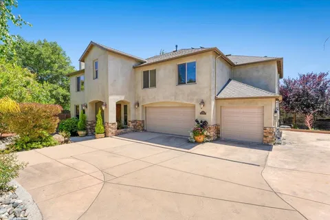 a backyard of a house with garage and chairs