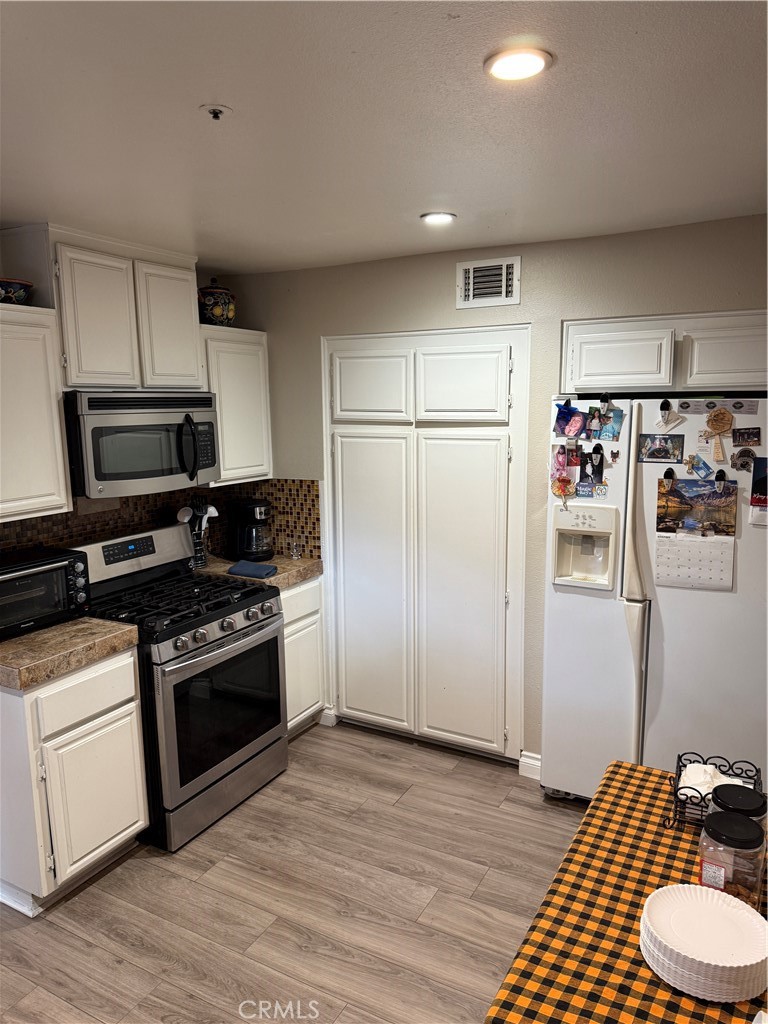 13584 Sutter Court Fontana, CA 92336 - Photo 9 of 46 a kitchen with stainless steel appliances a refrigerator stove and microwave