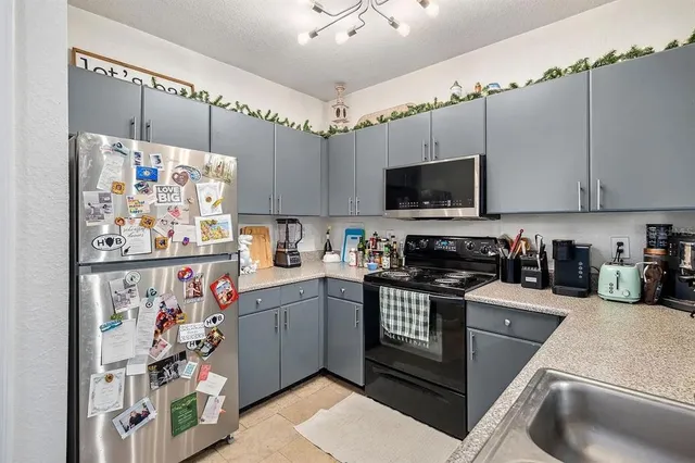 a kitchen with stainless steel appliances a stove a refrigerator and a sink