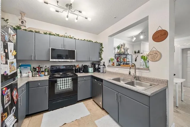 a kitchen with granite countertop a sink dishwasher stove and microwave with wooden floor