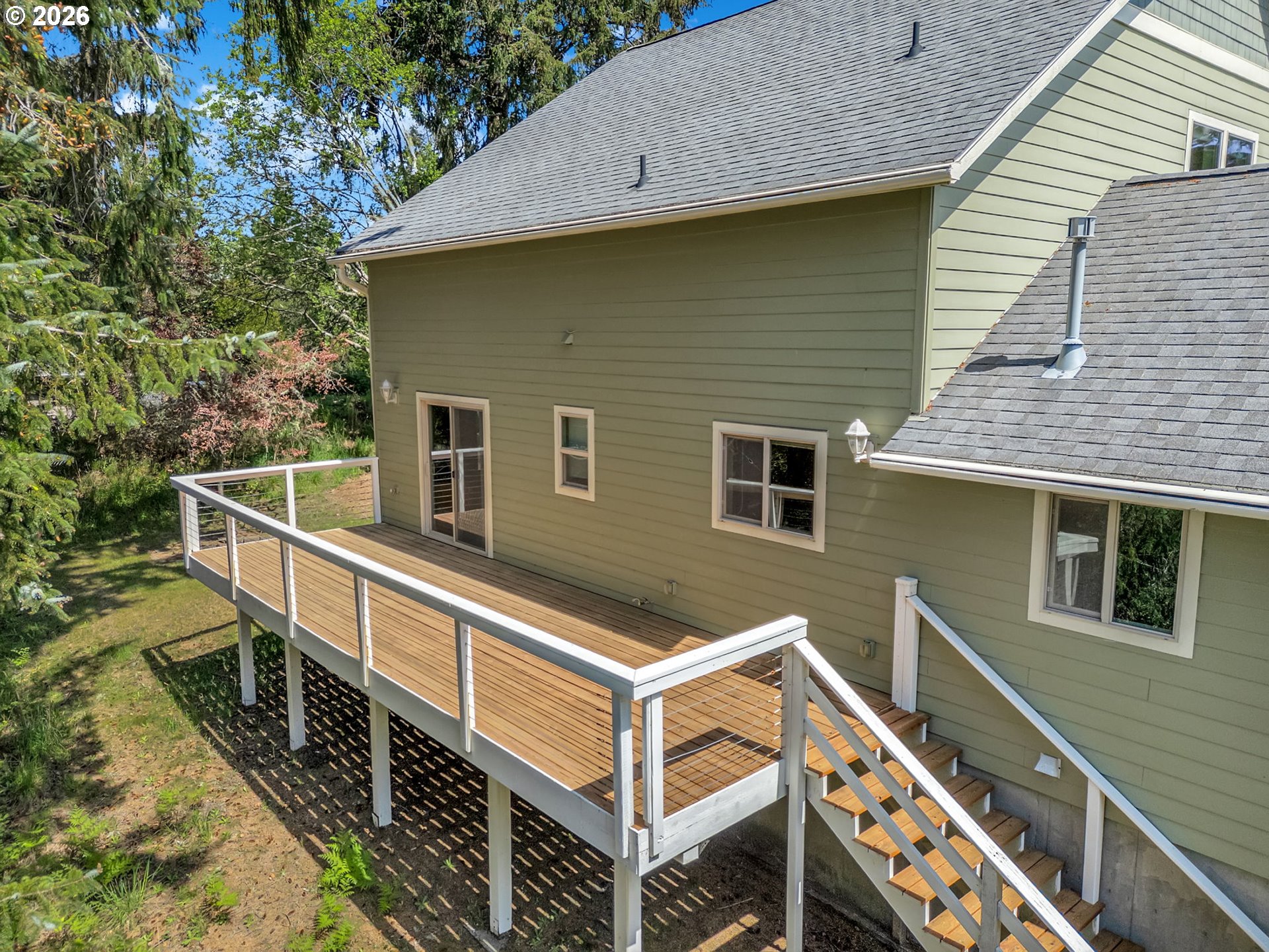 1077 Southwest Ridge Road Warrenton, OR 97146 - Photo 14 of 46 a view of a house with wooden deck and wooden fence