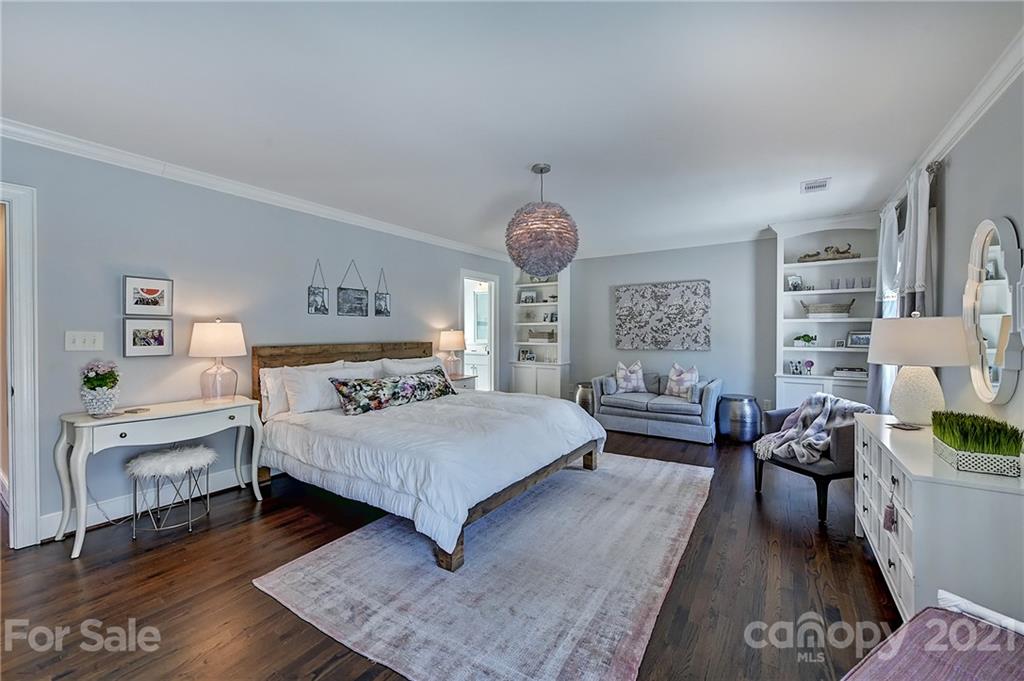 3400 Sharon Road Charlotte, NC 28211 - Photo 20 of 38 a bedroom with a bed a chandelier and dresser
