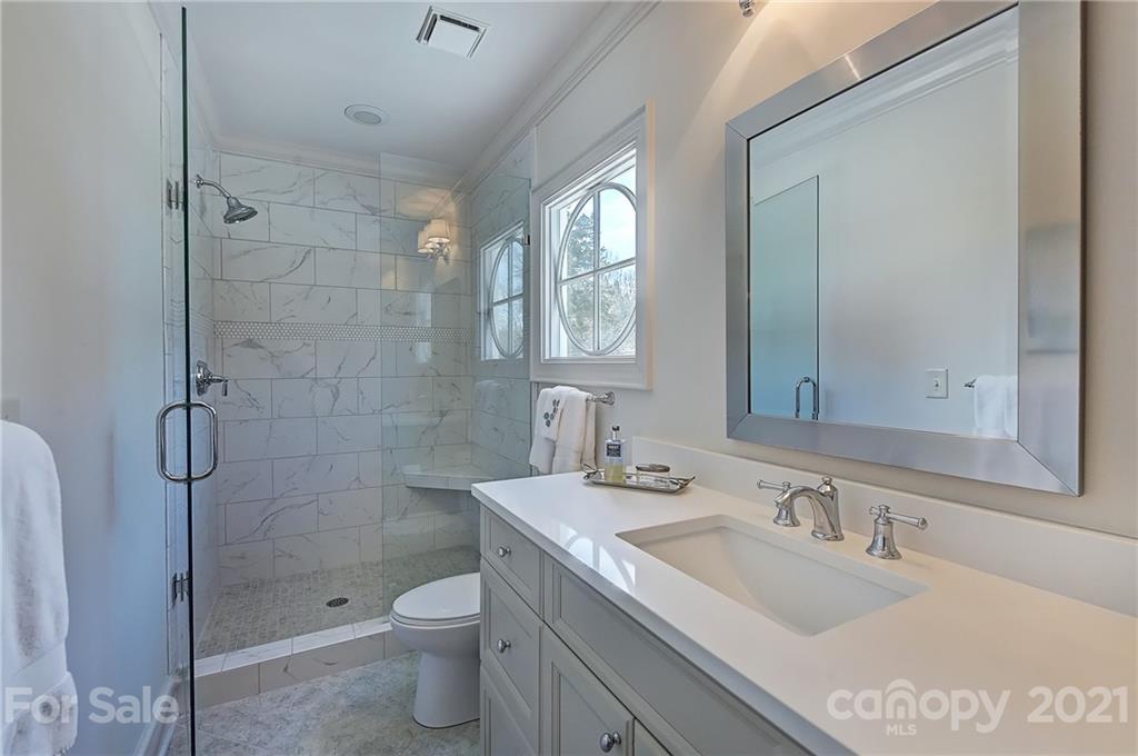 3400 Sharon Road Charlotte, NC 28211 - Photo 23 of 38 a bathroom with a granite countertop sink a toilet and shower